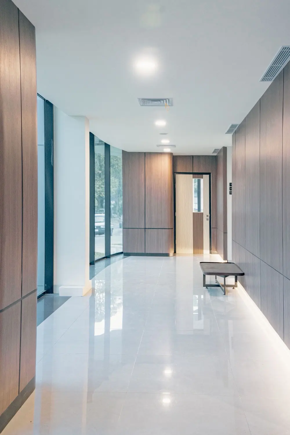 Quiet medical office hallway with wood-panelled walls and a bench